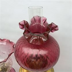 Victorian cast brass oil lamp, with fluted pink glass shade, together with two smaller brass oil lamps with pink shades and reservoirs and a pair of oil lamps, the bases modelled as putti, with pink glass reservoir  and frosted shades, tallest H70cm