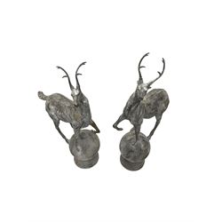 Pair of cast iron garden stag finials atop a sphere base, in rustic finish