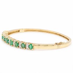 14ct gold emerald and diamond hinged bangle, nine oval cut emeralds, each spaced by two round brilliant cut diamonds, stamped 585, total emerald weight approx  2.15 carat, total diamond weight approx 0.50 carat