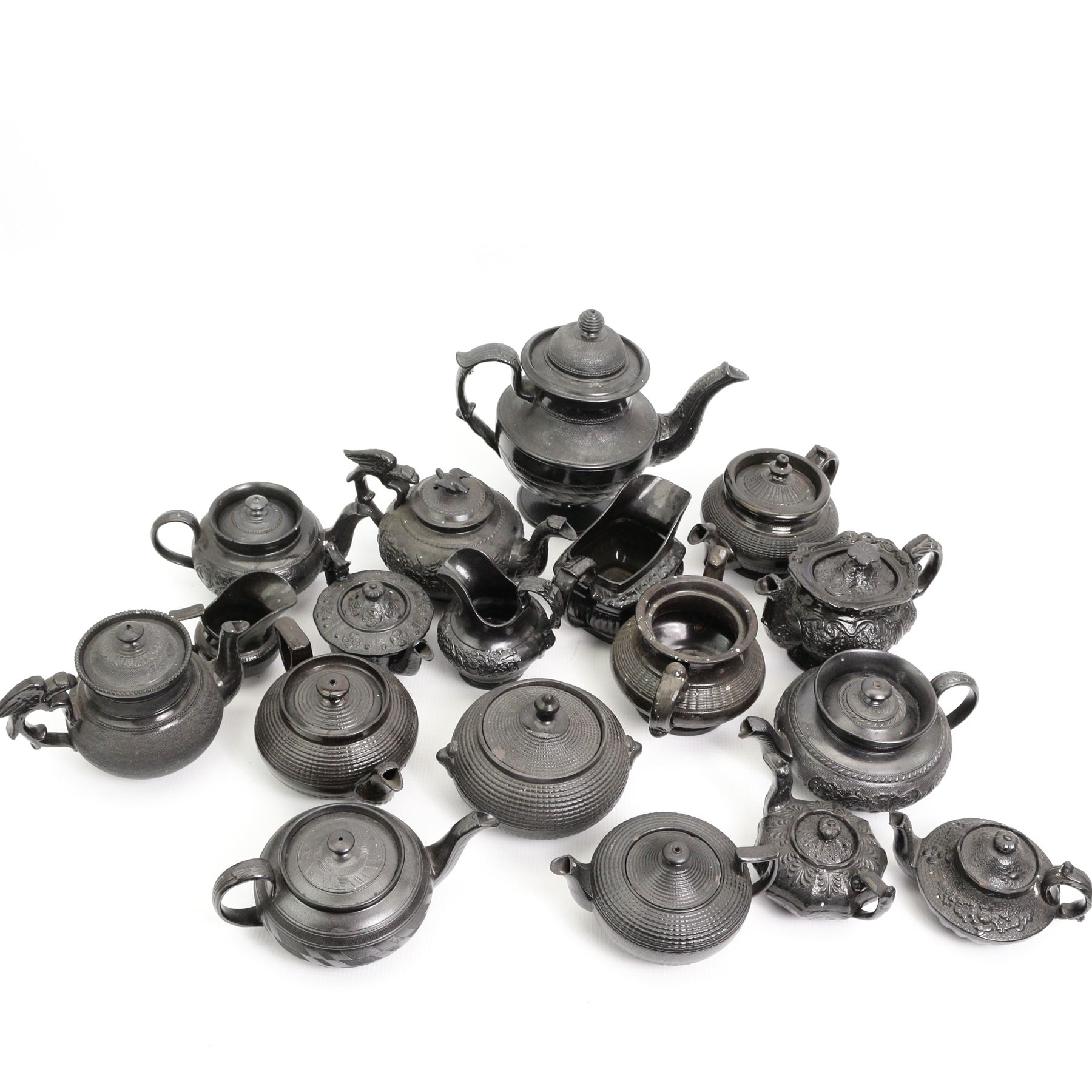 Early 19th century and later black basalt tea wares, mostly with relief or engine-turned bodies, including a Cyples bachelors teapot, other teapots, jugs etc in one box