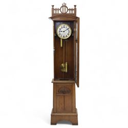 German-Art Deco 8-day longcase clock in an oak case, with a curved top and open fence work pediment, with reeded decoration and a fully glazed case door with a rectangular brass open work panel, on a tall rectangular plinth with a period  carved motif, circular slivered dial with Arabic numerals and spade hands, two train HAC (Hamburg and American Clock Company) weight driven movement, sounding the hours and half-hours on a coiled gong, with weights and pendulum.   