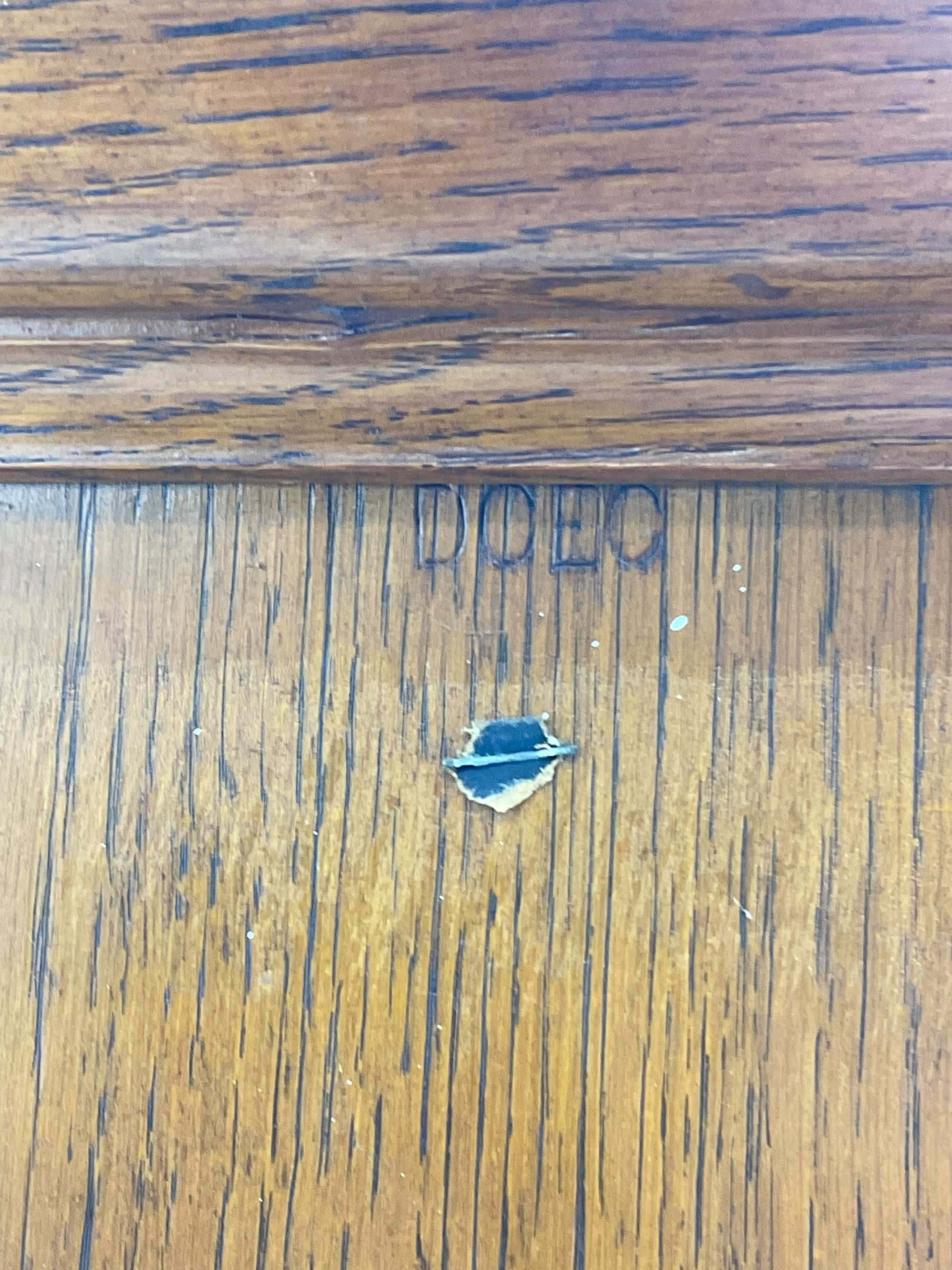 The North of England School Furnishing Company Limited Darlington - early 20th century oak school cupboard, projecting moulded cornice over two panelled doors, fitted with shelves, on chamfered plinth base 