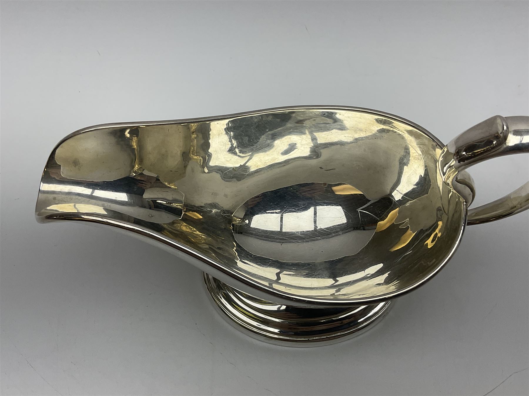 Christofle silver-plated sauce boat, of typical plain form, with capped C scroll handle and engraved anchor crest to body, upon a stepped oval foot, stamped 22 Christofle to base, including handle H14cm