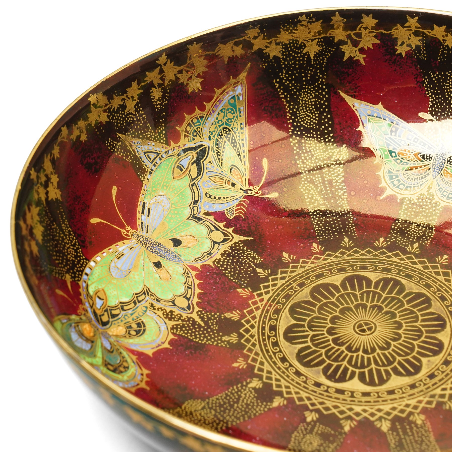 Four pieces of Fielding's Devon Lustrine, comprising a small pair of sleeve vases, H15cm; a bowl and vase, each decorated with butterflies and leaves in gilt on a red ground, printed marks beneath (4)