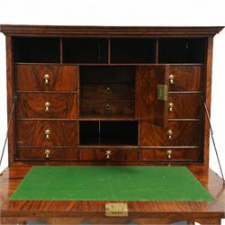 Early 18th-century George I walnut bureau cabinet on later stand, moulded rectangular cornice above fall front, inlaid oval burr walnut panel opening to reveal a fitted interior of drawers, pigeon holes, and a central cupboard door, with baize-lined writing surface above a long drawer over a shaped apron and turned legs joined by a turned stretcher, lacks key, later brass strut supports
