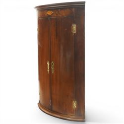 Georgian inlaid walnut cylindrical corner cupboard, projecting cornice over a banded frieze with inlaid shell motif, enclosing three shelves with two spice drawers fitted to base