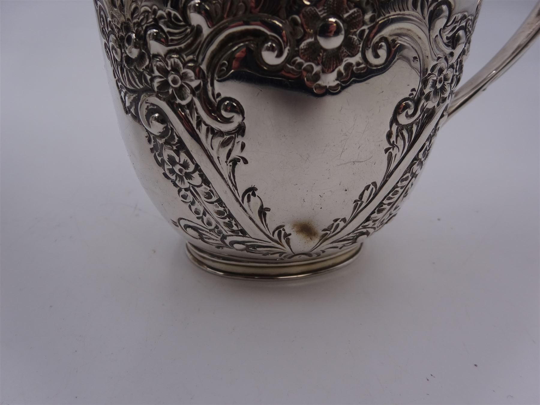 Late Victorian silver milk jug and twin handled open sucrier, each of oval form with angular handles and embossed floral, foliate and C scroll decoration, hallmarked James Deakin & Sons, Sheffield 1899, sucrier with handles H10.8cm