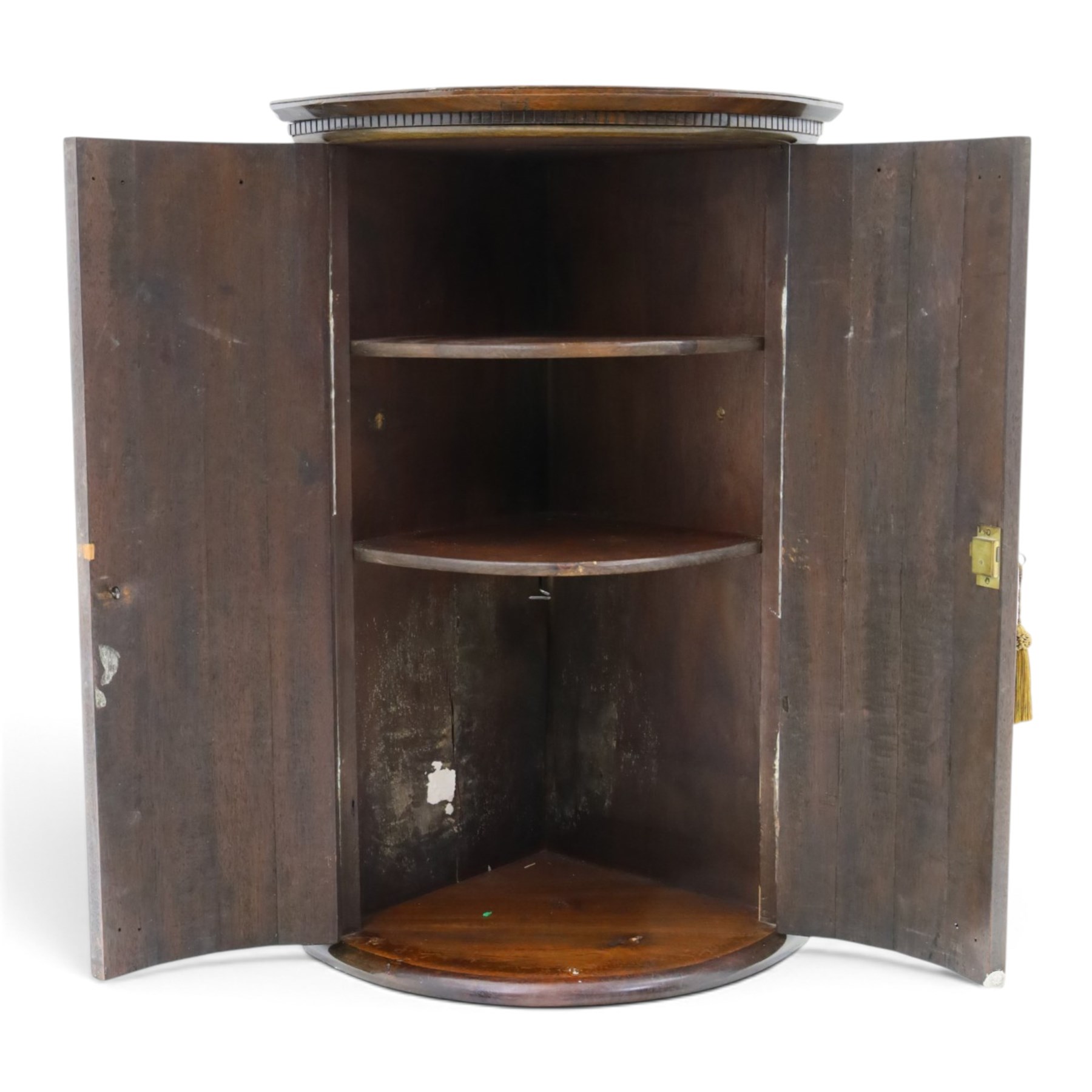 Small Georgian mahogany cylindrical hanging corner cabinet, projecting cornice with dentil carving, brass H hinges and escutcheons