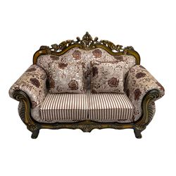 Italian Baroque design two seat sofa, hardwood framed, the cresting rail carved and pierced with c-scrolls and flower heads, scrolled arms, upholstered in floral patterned and striped fabric, with scatter cushions 