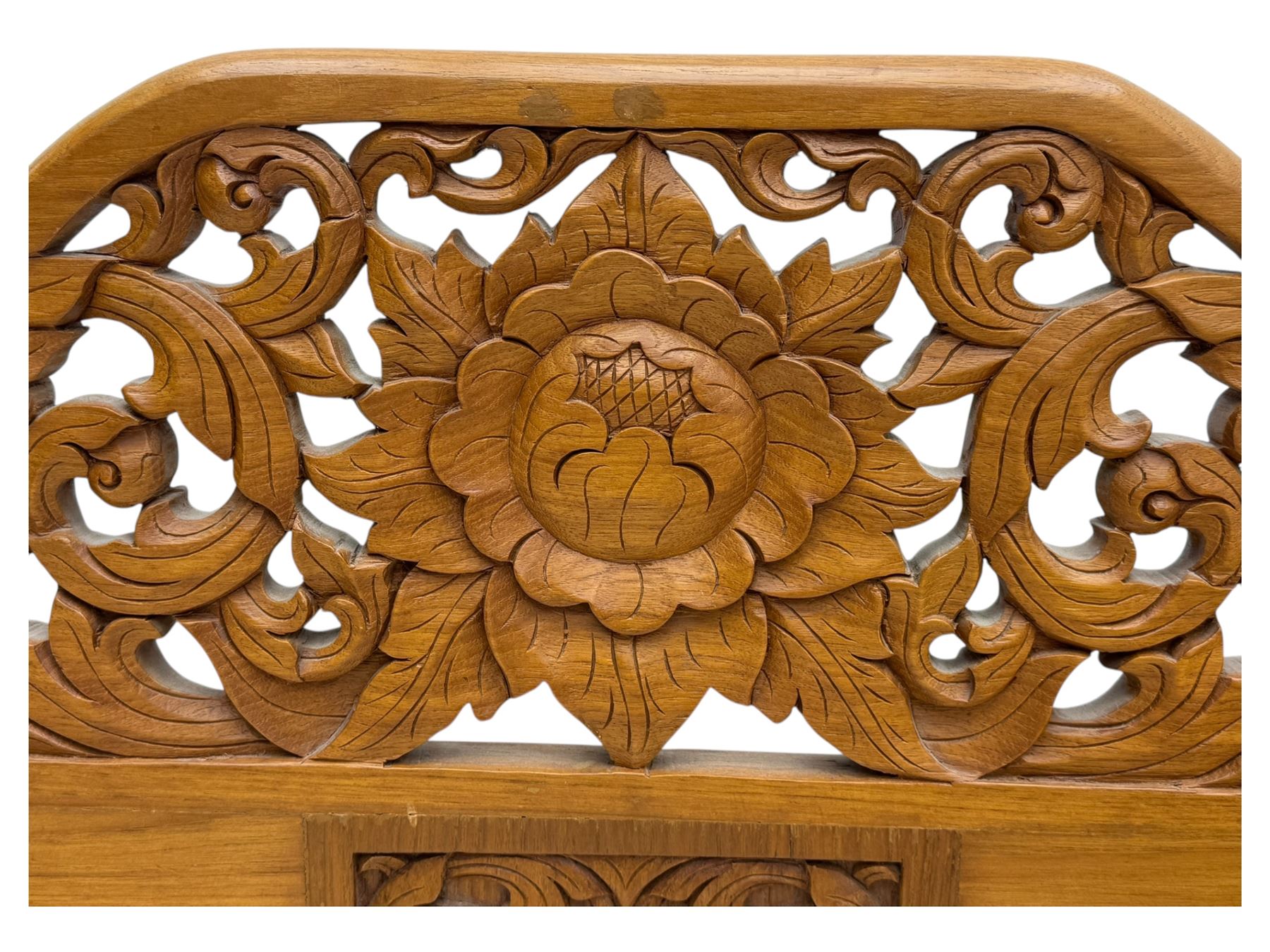 Early 20th century carved teak Howdah elephant chair, with pierced floral and foliate carved backrest, spindle gallery arm supports, cream upholstered cushions, splayed legs on a curved reeded base 