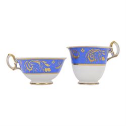 H&R Daniel trio, coffee cup, teacup and a saucer, circa 1825, Gadroon shape with D handle, painted with reserves of fine foliate sprays against a blue ground with gilt trellis detail, coffee cup including handle H8.5cm, saucer D14cm