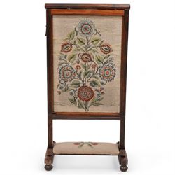Early to mid-19th century rosewood fire screen, lift-up needle work panel decorated with stylise floral pattern, moulded frame on platforms, lobe carved bun feet