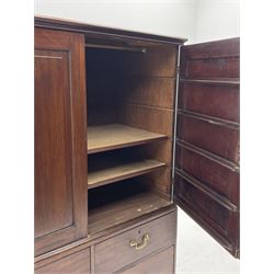 George III mahogany press cupboard on chest, projecting moulded cornice over two panelled doors, the interior fitted with hanging rail and two slides, the chest fitted with two short and single long drawer, on bracket feet 