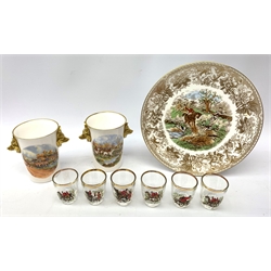  A collection of hunting related items, comprising a pair of Caverswall beakers, each with twin gilt fox head handles, H11.5cm, a limited edition Spode cabinet place depicting 'Drawing the Dingle' after J F Herring Sen, D24cm, and a set of six French shot glasses, decorated with huntsmen on horseback and hounds, H5.5cm.  