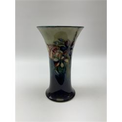 Moorcroft vase of trumpet form, decorated in the Spring flowers pattern upon a merging blue and green ground, with impressed and painted marks beneath, H20cm. 