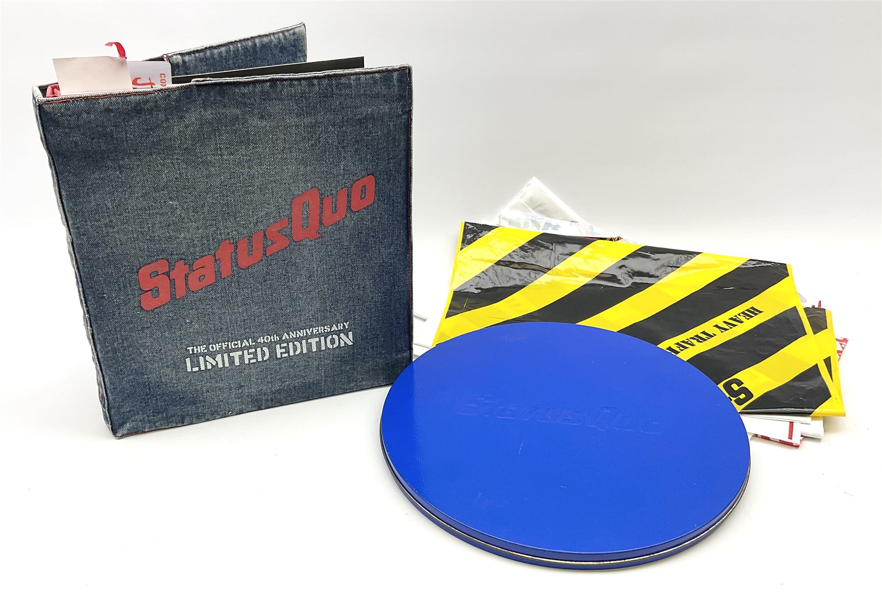 Status Quo: The Official 40th Anniversary Limited Edition book No.926/3000 with certificate signed by Rossi and Parfitt. Duplicate signatures by Rossi and Parfitt on pages within the book. Denim dustjacket; 'From The Makers Of ....' boxed set of three LP records in circular blue tin; and quantity of tour carrier bags
