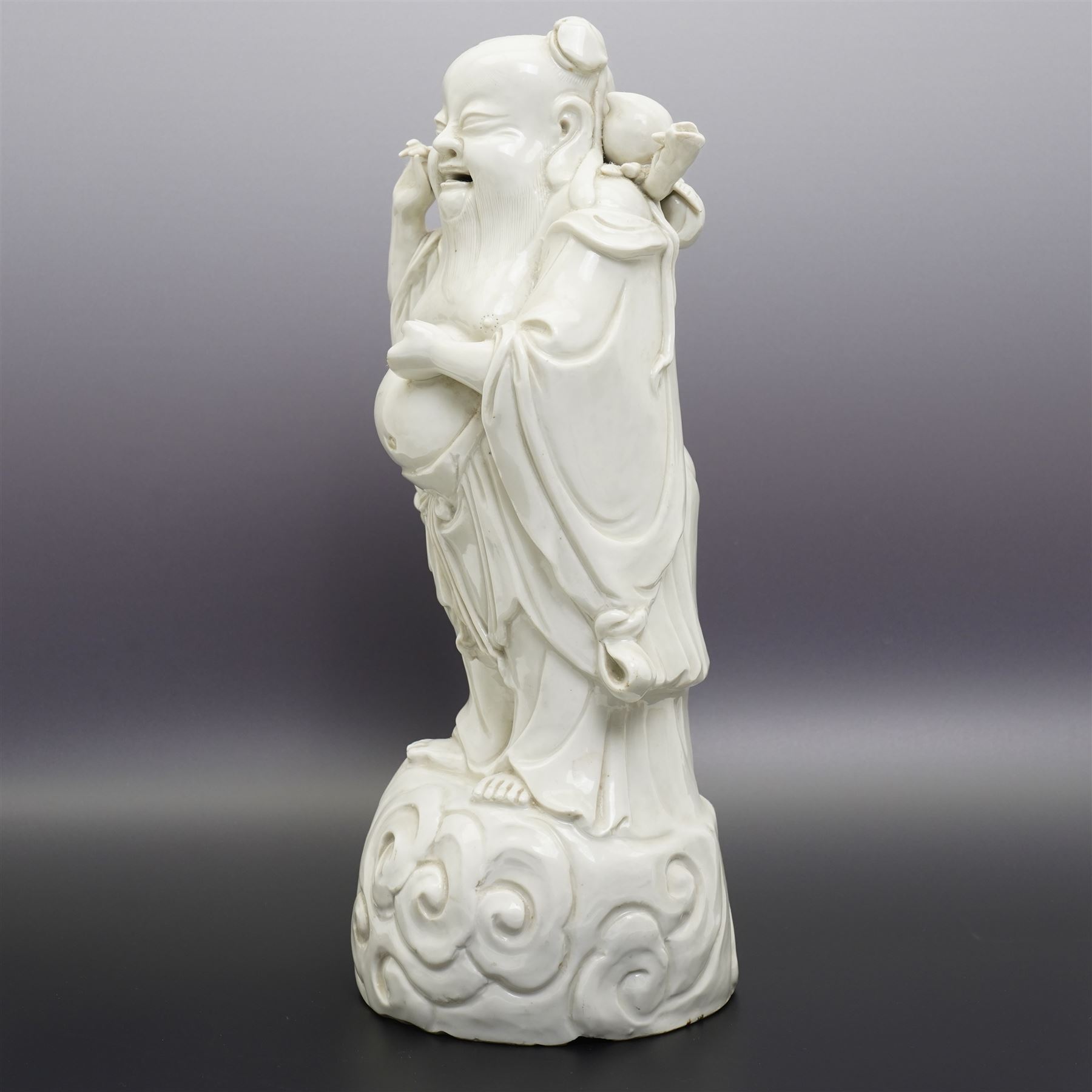 Chinese blanc de chine figure of Shou Lao, standing upon a cloud, H36cm 