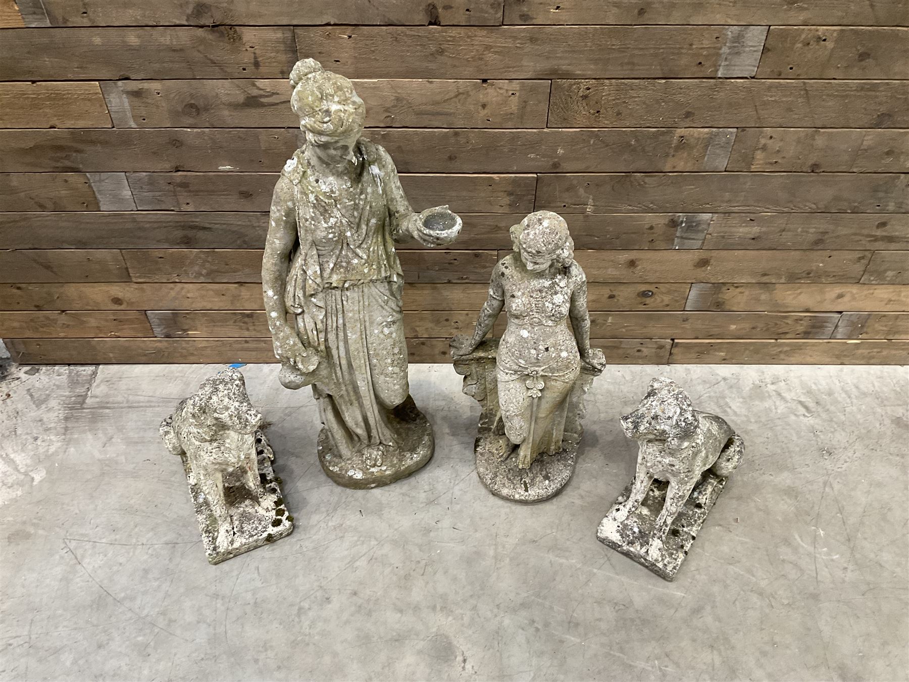 Pair of cast stone garden dogs and 2 female figures,