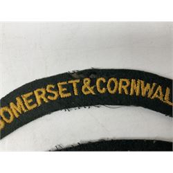 Pair of Civil Defence Corps armbands; and three cloth shoulder titles for Somerset & Cornwall L.I (2), Lancashire (PWV) and Devon & Dorset Regiments (6)