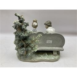 Lladro figure, Poetry of Love, modelled as a boy seated reading from a book next to a girl on garden bench with a dog at her feet, sculpted by Regino Torrijos, with original box, no 5442, year issued 1987, year retired 1998, H22cm