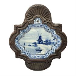 Delft blue and white plaque with decorate with a windmill in a landscape, with stylized flower boarder, within a oak frame, with impressed and painted marks to the back, H38cm