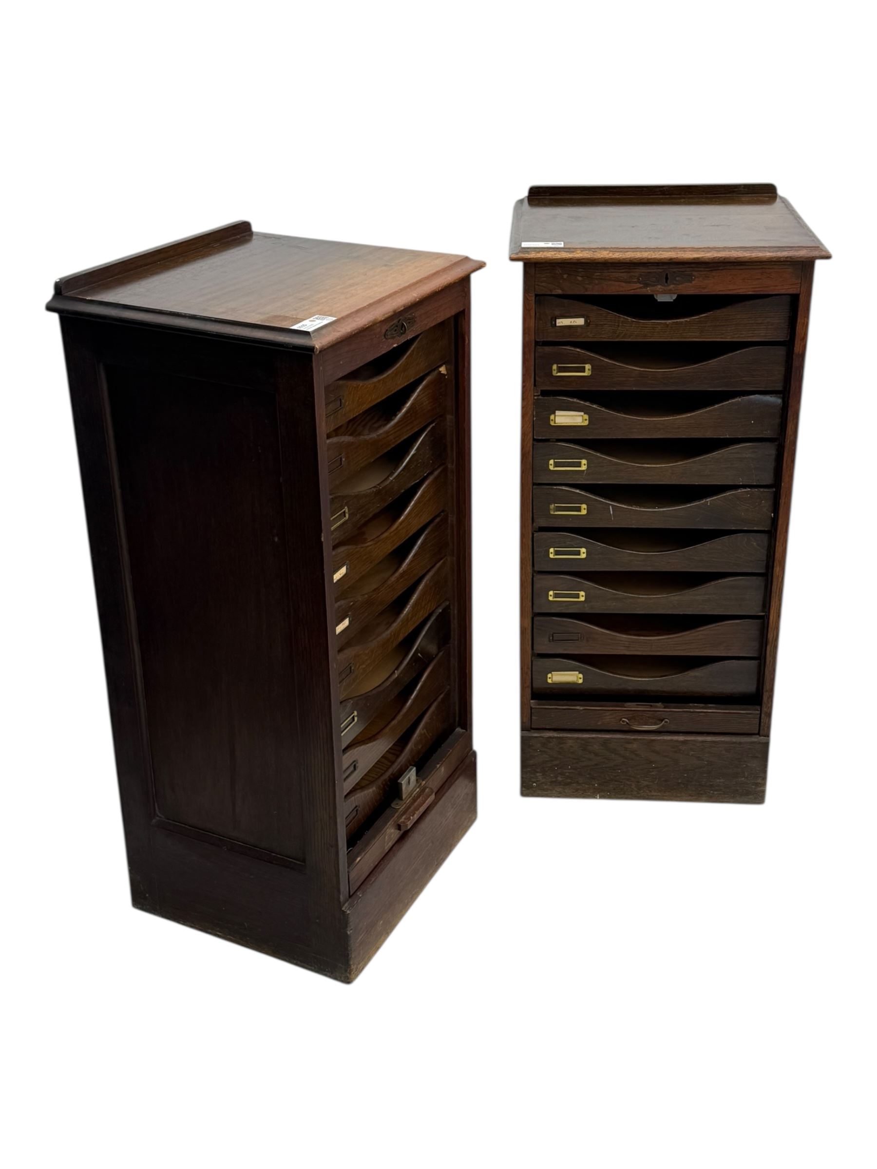 Two early 20th century mahogany tambour cabinets, each with retractable roll-top front revealing fitted interior with concave-front filing drawers and brass fittings
