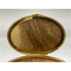 Alabaster box of oval form, gilt mounted with griffins and aquila signifers, the hinged lid finished with an eagle clasp, raised upon four claw feet, L18cm, H18cm