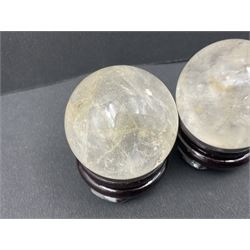 Pair of quartz spheres, upon carved wooden stands, D4cm