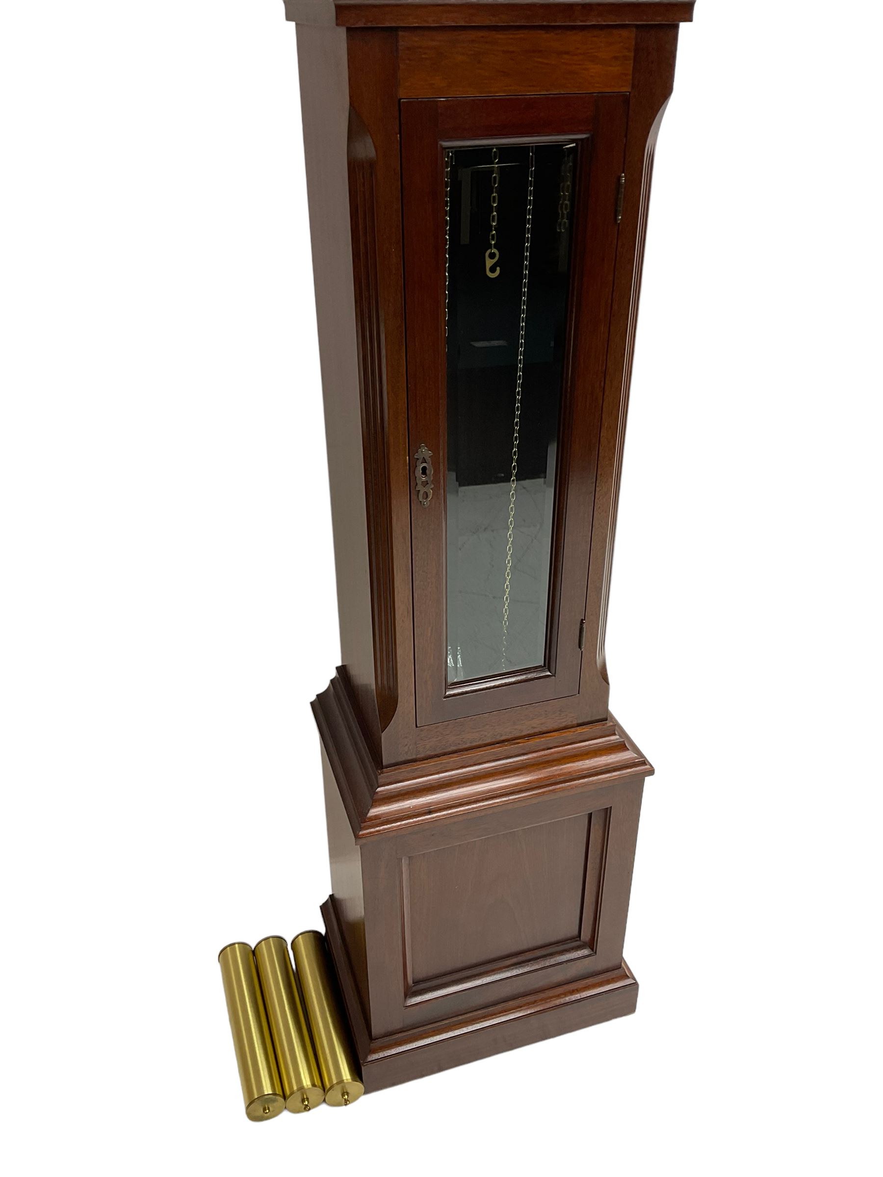 Mahogany cased Grandmother clock c 1980 made and retailed by Julian Stanton, Winchester, with a break arch pediment and corresponding brass dial, full length glazed door displaying three brass cased weights and pendulum, raised on a square plinth with a recessed panel and skirting, German Kieninger three train chain driven movement striking the hours and quarters on 12 gong rods. With weights and pendulum.  