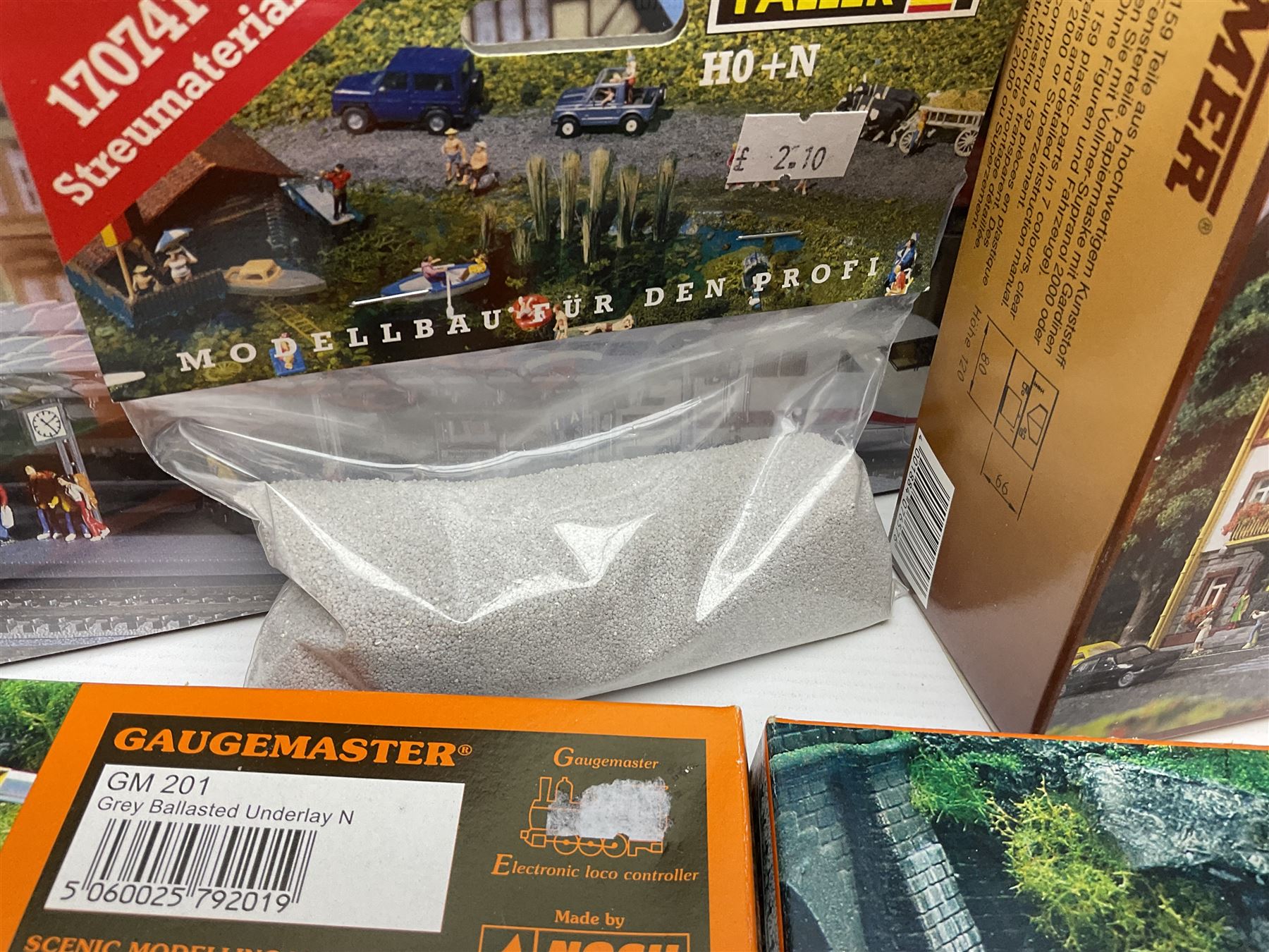'N' gauge trackside accessories - seven Faller buildings and bridges etc Nos.N212113, N222121, N222583, N222174, N222128, Z282730 & Z282707; two others by Vollmer Nos.N7657 & N7724; four boxes of Gaugemaster Ballasted Underlay; grit and Foliage Clusters