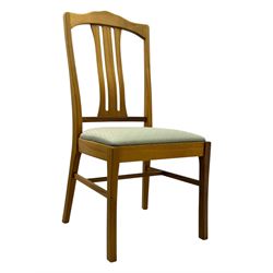 G-Plan - mid-20th century teak extending dining table, oval top with concealed central butterfly leaf extension, raised on splayed supports with cross-stretcher; three dining chairs with curved top rail and vertical splats