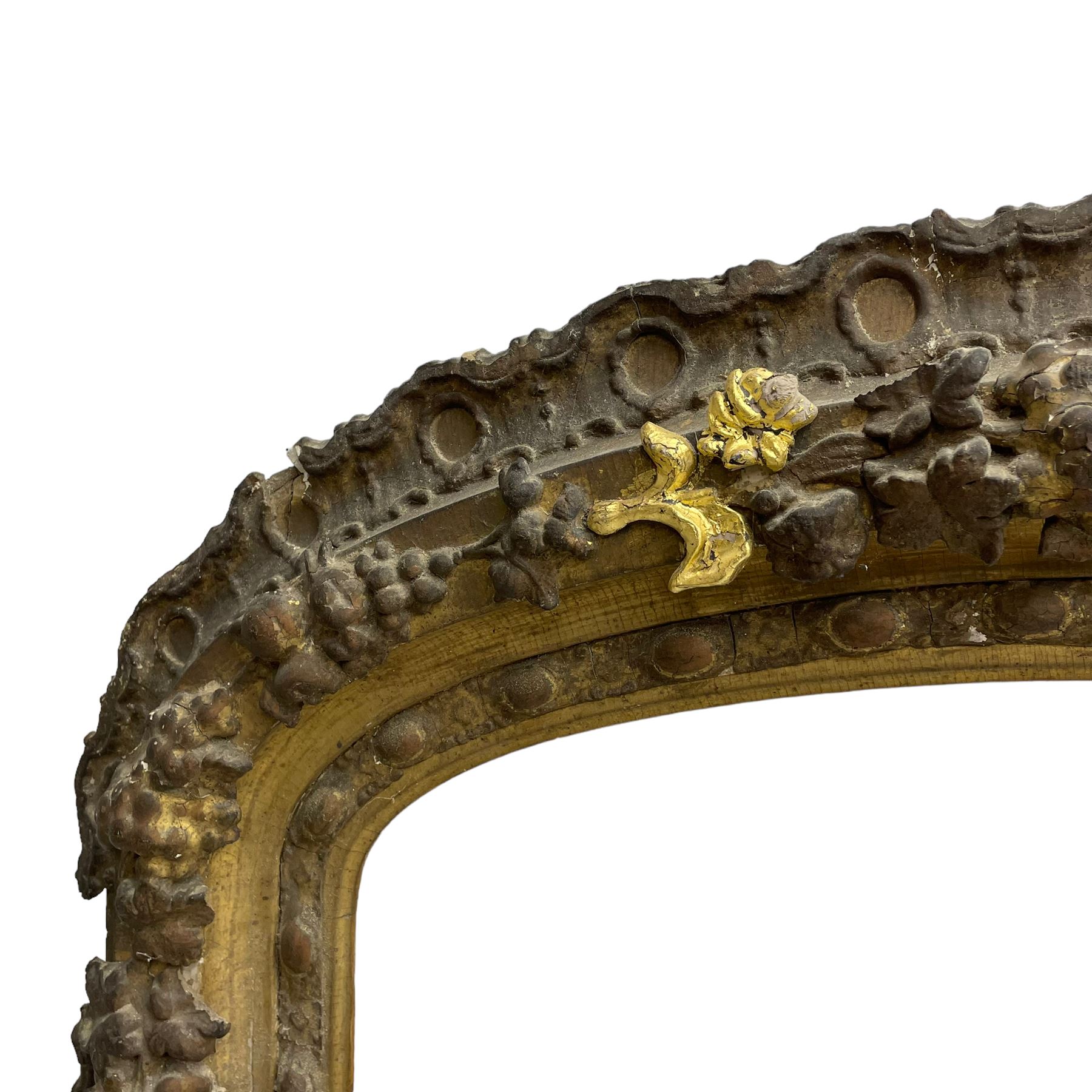 19th century giltwood and gesso moulded picture or mirror frame, the arched cresting rail mounted by central cartouche decorated with foliate scrolls and fruit, the outer frame decorated with scalloped edge and shell mouldings, trailing foliage with flower head and fruit to the central band, egg and dart moulded inner slip