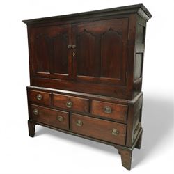 18th century oak dwarf press cupboard, the upper section with twin arched panel doors above three short and two long drawers, each with brass plate handles, shaped apron and stile feet, of compact country form