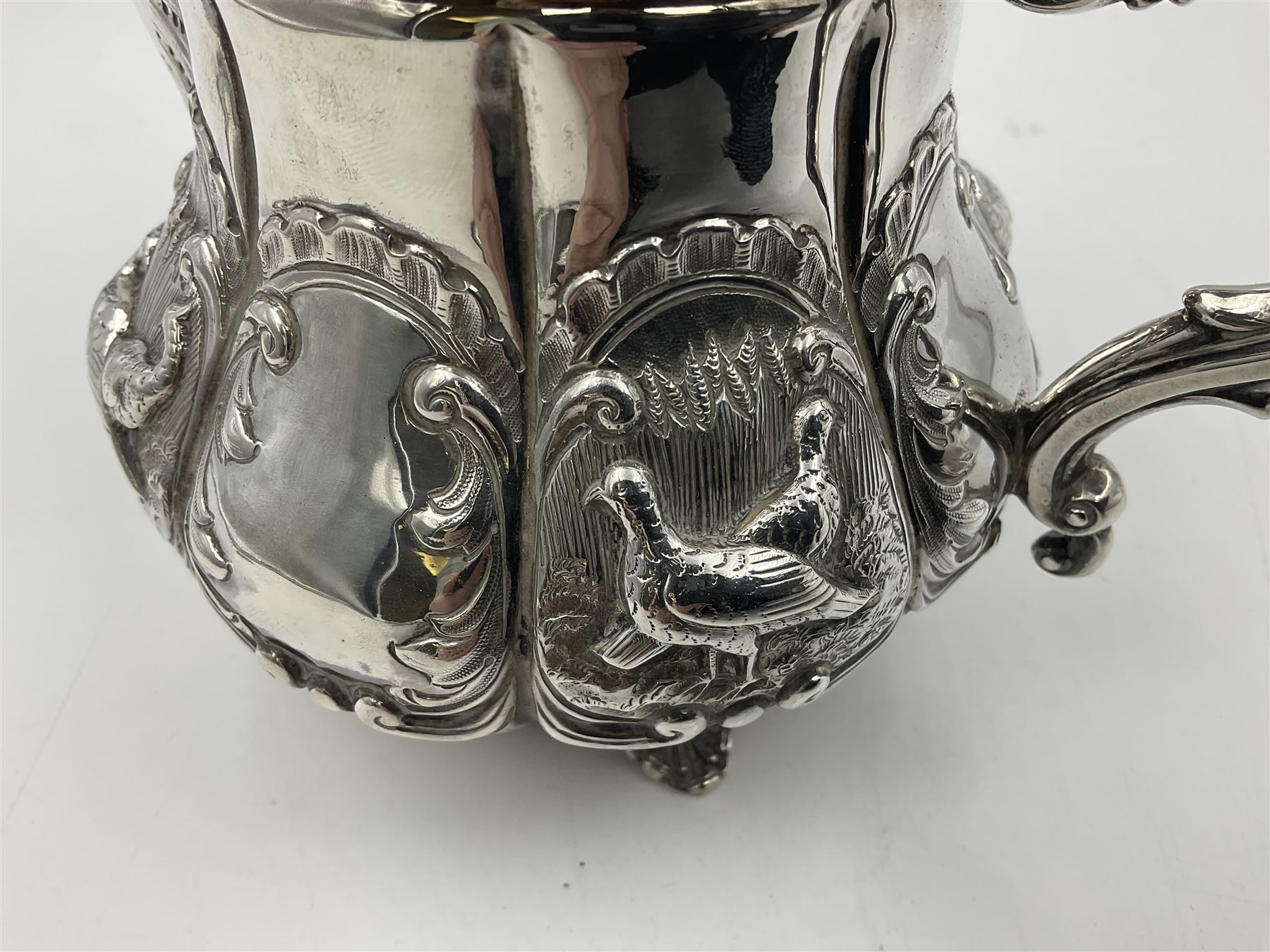 Victorian silver three piece tea service, comprising teapot, twin handled open sucrier, and milk jug, each of bellied form with acanthus capped scroll handles, the sides embossed with alternating scroll edged vacant panels and panels containing a pair of birds, upon four palmette feet, the teapot with ivory insulators to handle, and bird finial to the hinged domed cover, hallmarked William Hunter & Son, London 1861, teapot H19cm, including handles sucrier H13.5cm, including handle milk jug H12cm

This item has been registered for sale under Section 10 of the APHA Ivory Act