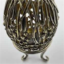 Modern silver limited edition Easter egg, no. 70/500, the gilt openwork body decorated with cascading bluebells and hinged cover with pierced circular panel set with a single faceted purple stone, opening to reveal a gilt interior, upon silver stand with three scrolling pad feet, each hallmarked St James House Company, London 1981, height including stand 8cm