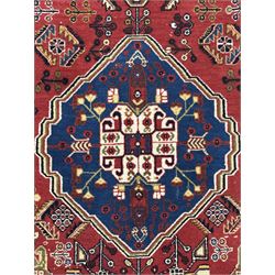 Fine Persian Qashqai crimson and navy ground runner, three large medallions filled with geometric and floral designs, the field with angular vines and stylised floral decoration, wide ivory border decorated with repeating floral and angular motifs