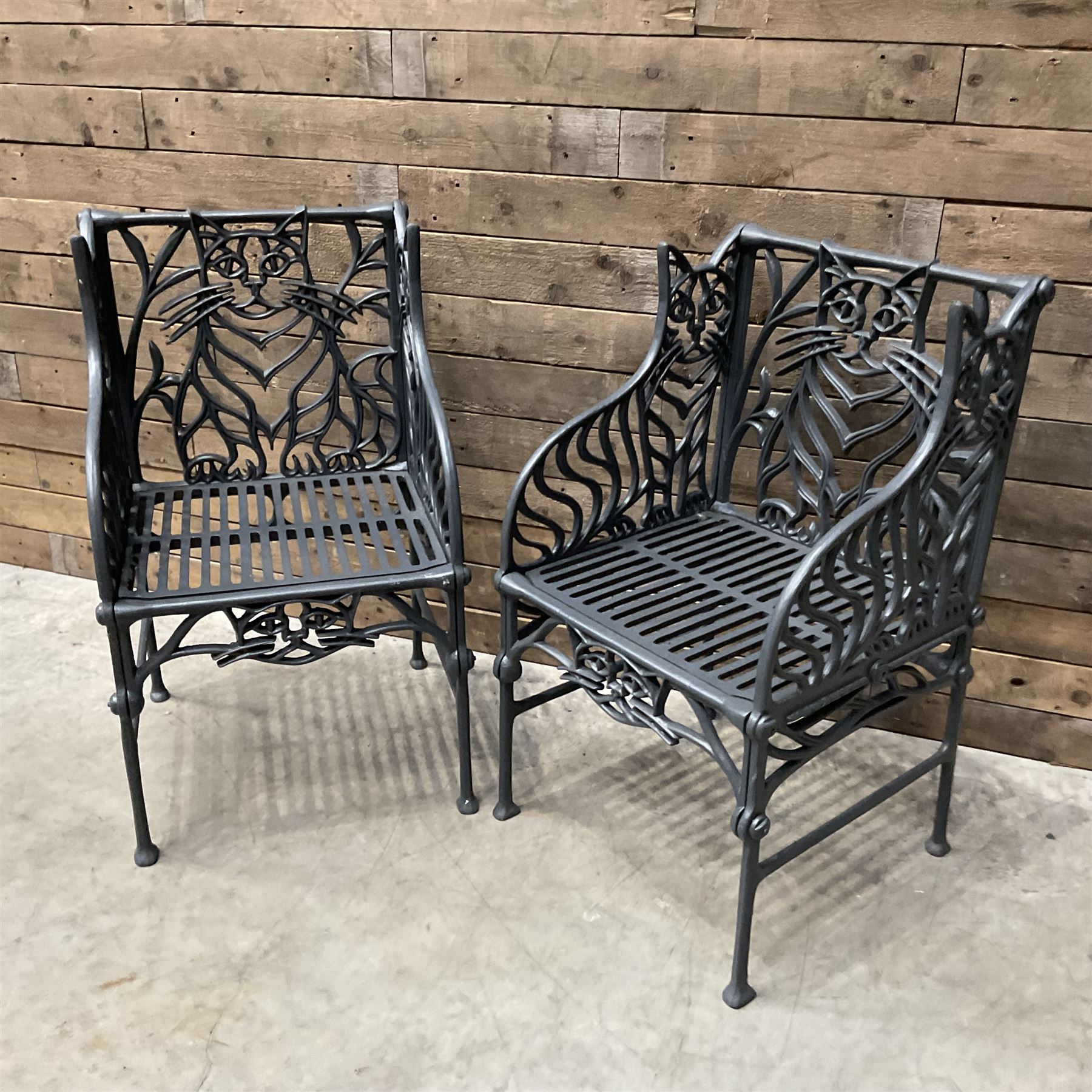 Richard Bawden (1936-2024): Pair of Cat design painted cast iron garden armchairs