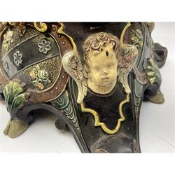 Composite table lamp modelled as a Roman Emperor donning blue robes, upon quatrefoil base modelled with rams heads and winged cherubs, H56cm excl fitting