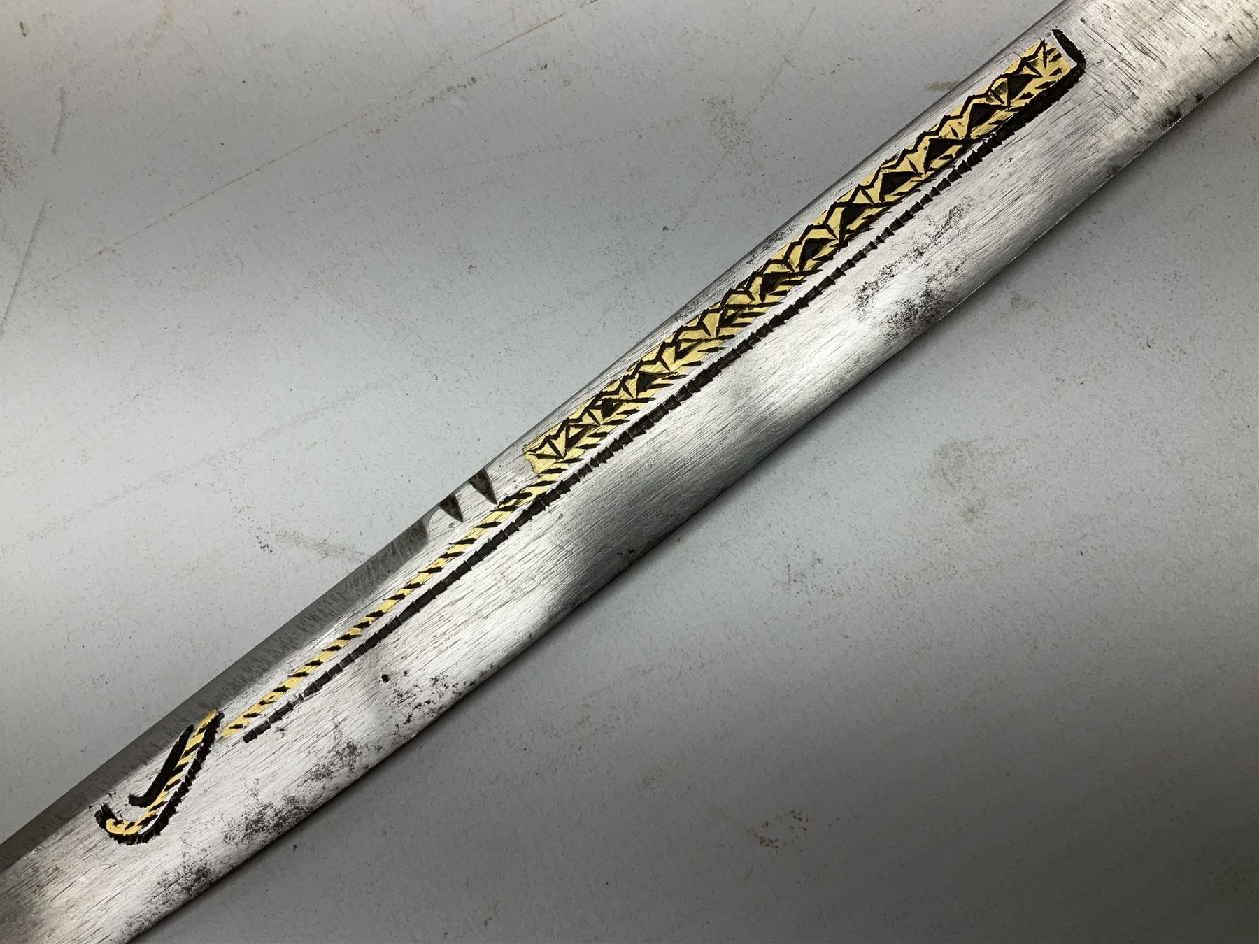 19th century Algerian Flyssa long knife, the 34cm single edged pointed decorative blade inset with yellow metal, chased brass grip with pommel as the snout of a stylised animal and carved hardwood scabbard L45cm overall
