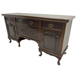 Late Victorian walnut sideboard, moulded rectangular top over three drawers  with blind fretwork facias, fitted with central fall front cupboard with extending foliage carved decoration and two flanking panelled cupboards, on acanthus carved cabriole feet