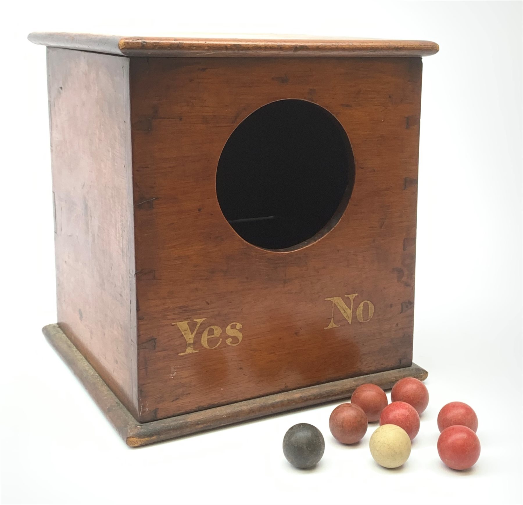 A Victorian mahogany ballot box, detailed Yes and No, H25cm, with six red, one black, and one white clay balls, probably of the same period. 