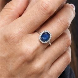 18ct white gold sapphire and diamond cluster ring, single cushion cut sapphire of approx 4.20 carat, surrounded by twenty round brilliant cut diamonds, stamped 750, total diamond weight approx 0.50 carat
