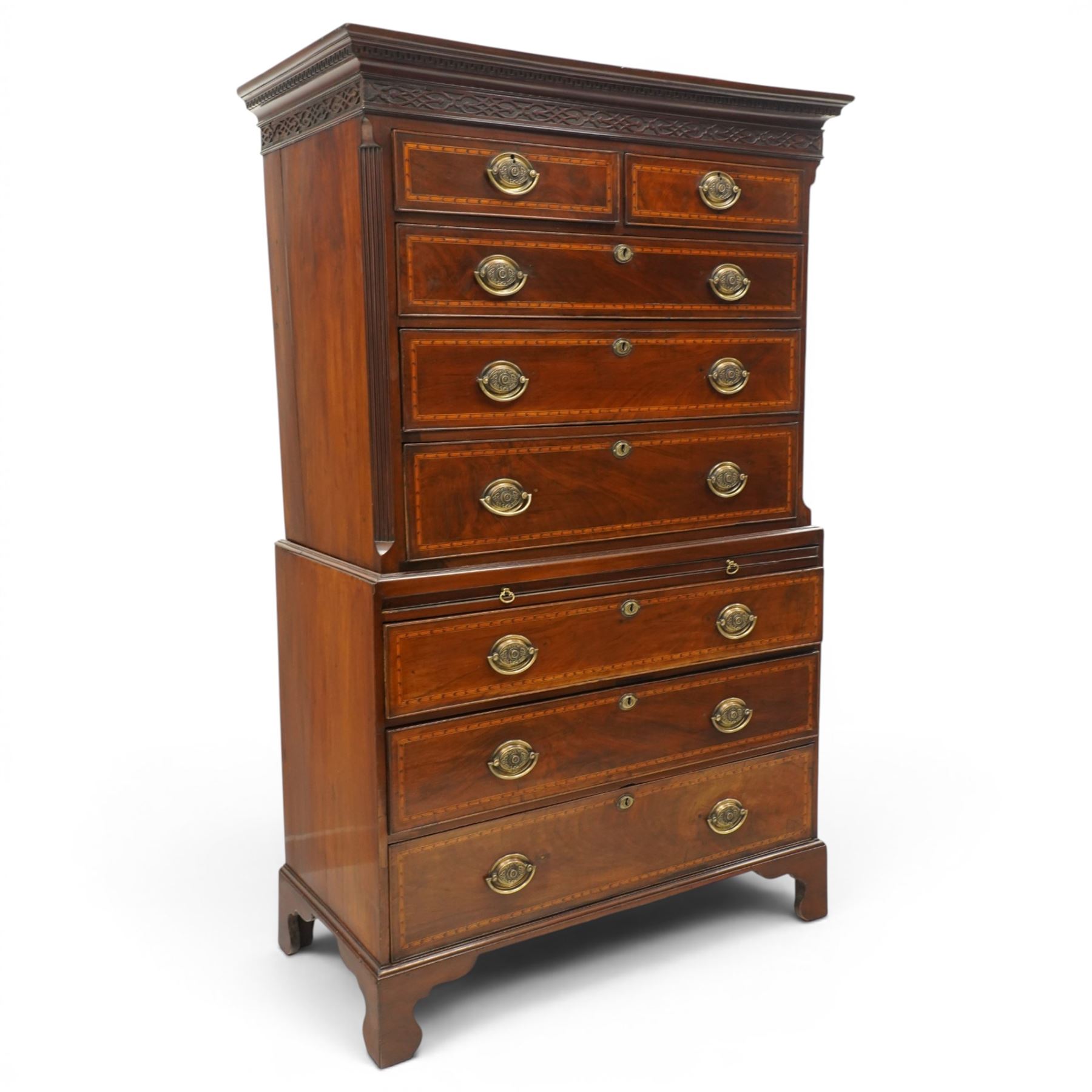  Late 18th century mahogany and inlaid chest on chest, projecting cornice above blind fretwork in laid drawers, the upper chest with two short over three graduating drawers, the lower section with brushing slide over three long graduated drawers, raised on bracket feet