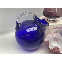 Mid-century cobalt blue glass pitcher of tilted spherical form with clear handle, together with three cups, the bowls of spherical form raised upon tapering feet, and further glass ware to include Mdina seahorse paperweight, boxed Swarovski butterfly figure, two Caithness vases, and art glass, pitcher H24cm