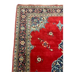 Persian Kashan crimson ground rug, the field decorated with interlacing medallion, floral design spandrels, guarded border with scrolling design decorated with stylised plant motifs