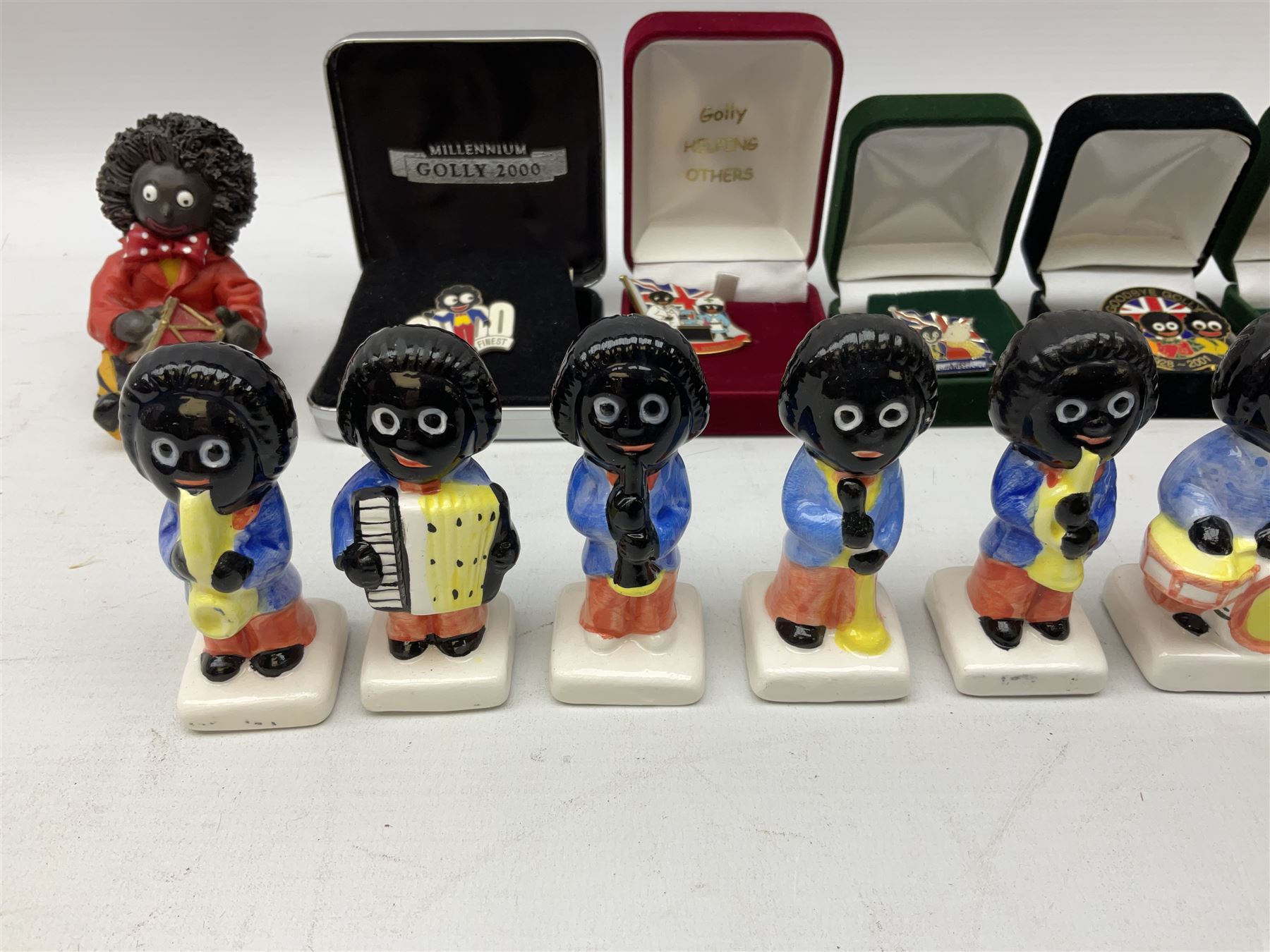 Eight ceramic Golly Band figurines marked Carlton Ware, together with four other Golly figures and five boxed badges