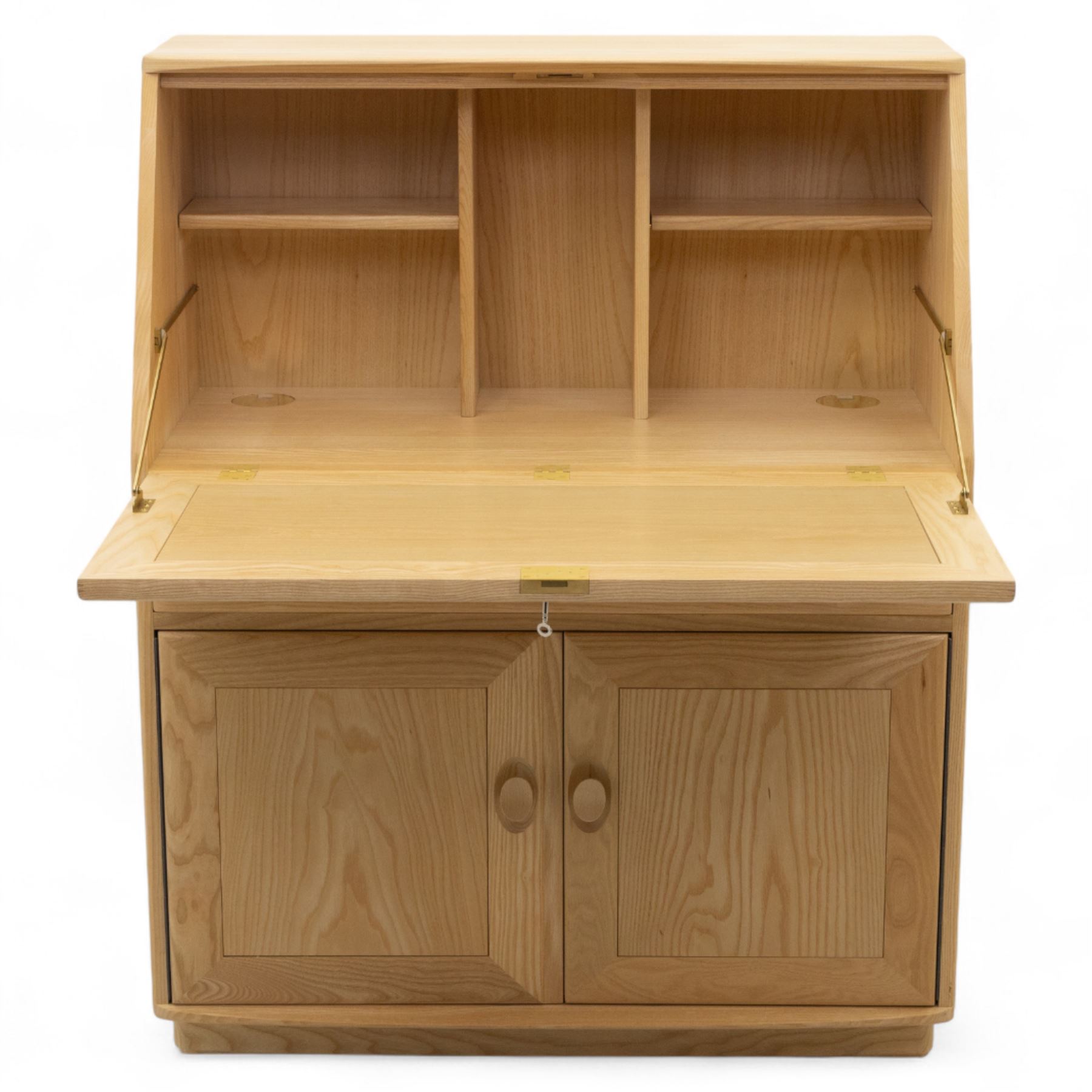 Ercol - light elm bureau, fitted with fall-front writing surface revealing adjustable shelving, above a single long drawer and twin cupboard doors, on plinth base