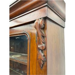 Victorian mahogany bookcase on cupboard, projecting cornice over two glazed doors and carved corbels, fitted with two drawers and double cupboard, plinth base