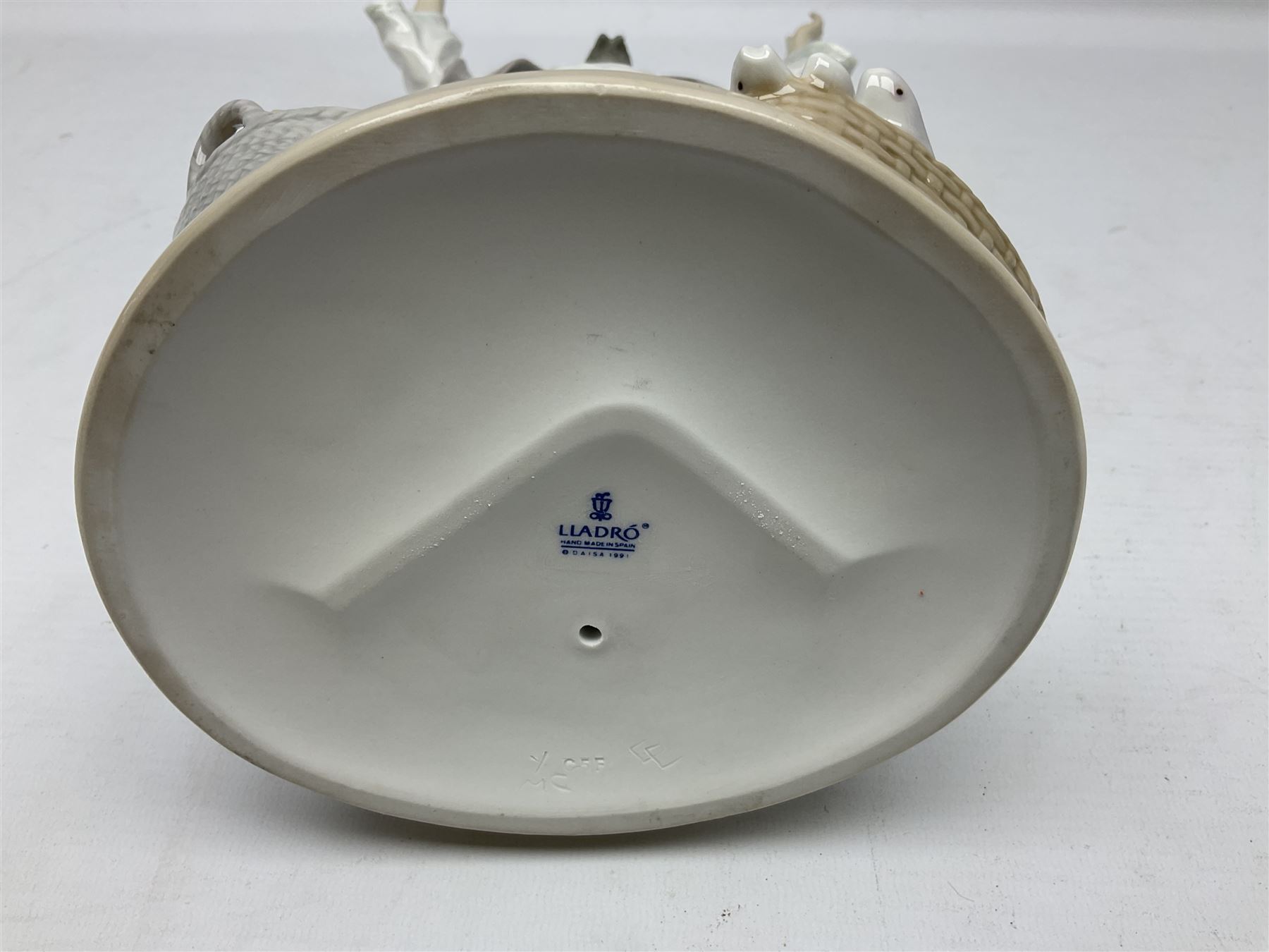 Lladro figure, The Loaves and Fishes, modelled as Jesus Christ with arms raised standing beside a basket of loaves and a basket of fish, sculpted by Salvador Furió, with original box, no 5896, year issued 1992, year retired 1997, H35cm