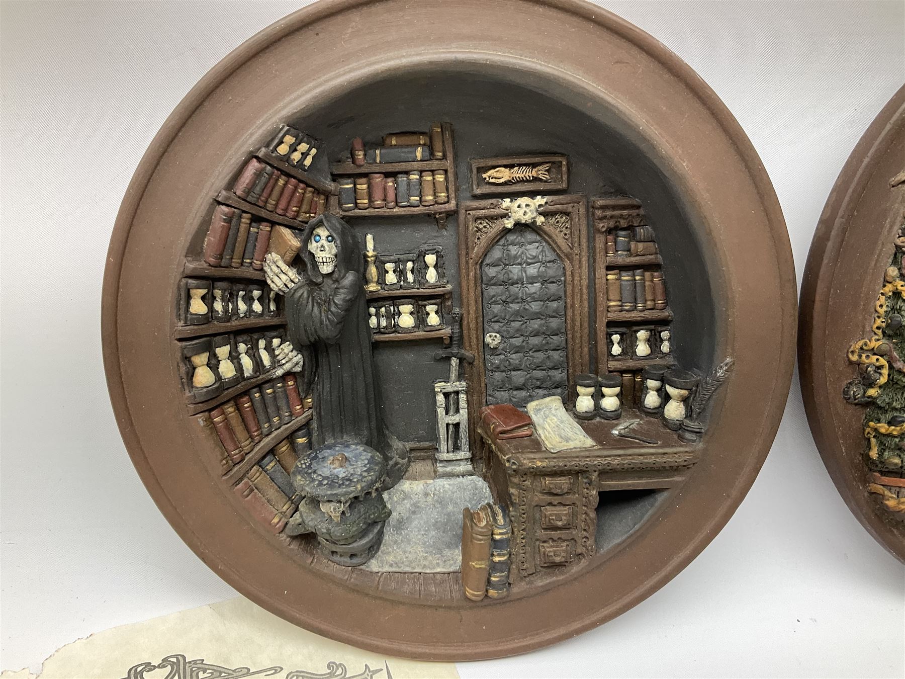 Two Terry Pratchett Discworld limited edition sculptured bas-reliefs, designed by Clarecraft, comprising Death Study created by 'the cunning artificer, Bernard the stout', 132/500 and The Hogfather, created by 'the cunning artificer, Bernard the stout', 132/500, both with certificates of authenticity.   